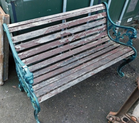 A 20thC cast iron garden bench, with green painted metal ends and wooden slat supports, 78cm high, 137cm wide, 51cm deep.