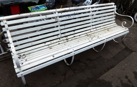 A wrought iron and white painted three sectional garden bench, with arched back, 85cm high, 235cm wide, 65cm deep.