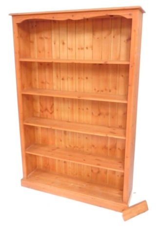 A pine open bookcase of five shelves, raised on a plinth base, 182cm high, 122cm wide, 29cm deep.