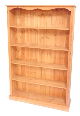 A pine open bookcase of five shelves, raised on a plinth base, 182cm high, 122cm wide, 29cm deep.