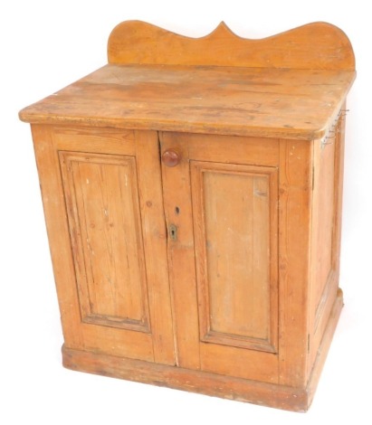 A Victorian pine kitchen cupboard, with a shaped back, above two doors opening to reveal a long drawer and two shelves, raised on a plinth base, 106cm high, 89.5cm wide, 63cm deep.