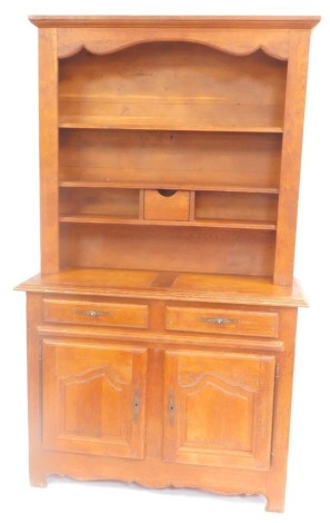 A 20thC oak dresser, the out swept pediment over three shelves, with a drawer to the lower shelf, above two drawers and a pair of panelled doors, raised on bracket feet, 224cm high, 132cm wide, 54cm deep.