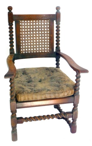 A 19thC Carolean style carver chair, with a carved and cane back, cane and loose cushion seat, raised on barley twist supports united by stretchers, 68cm high.