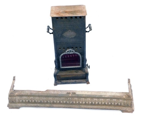 A late 19thC Continental tin Flamme Bleue burner stove, 62cm high, together with a Victorian cast iron bedroom fender, 93cm wide. (2)