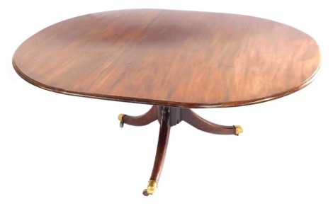 A late Georgian mahogany oval tilt top breakfast table, raised on a turned column, over three out swept legs, brass capped on castors, 70cm high, 156cm wide, 133cm deep.