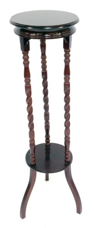 A stained mahogany jardiniere stand, raised on turned and spiral twist columns, united by an under tier, above scroll legs, 105cm high.