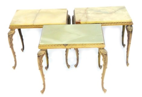 A 1970s set of three brass and green onyx occasional tables, raised on cabriole legs, each 36cm high, 44cm wide, 35cm deep.