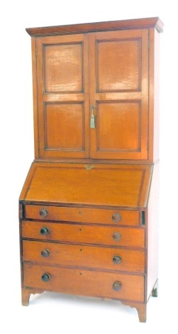 A George III oak and mahogany cross banded bureau bookcase, the outswept pediment over a pair of doors enclosing two shelves, above a fall flap opening to reveal one long and eight short drawers, and four recesses, over four long graduated drawers, raised