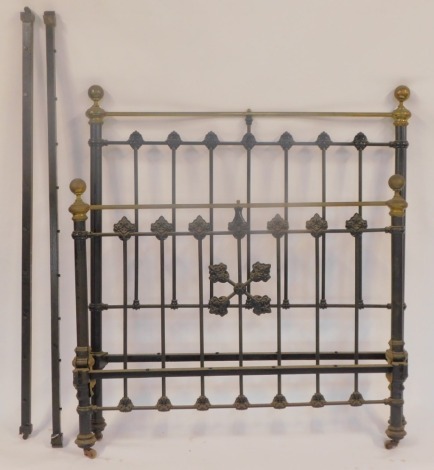 A Victorian metal double bed frame, comprising headboard, footboard, and two support rails, on ebonised black ground, with shell capped supports and brass ends, 161cm high, 134cm wide.