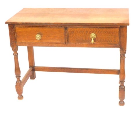 A Victorian oak side table, with two frieze drawers, raised on baluster turned columns united by stretchers, 76cm high, 102cm wide, 51cm deep.