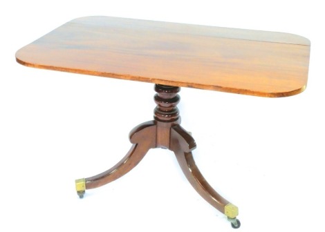 A late Georgian mahogany tilt top breakfast table, raised on a turned column with three out swept legs, brass capped on castors, 72cm high, 118cm wide, 81cm deep.