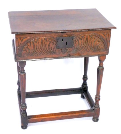 An 18thC oak bible box, with a foliate carved frieze, raised on a turned table base, united by a box stretcher, 76cm high, 66.5cm wide, 41cm deep.