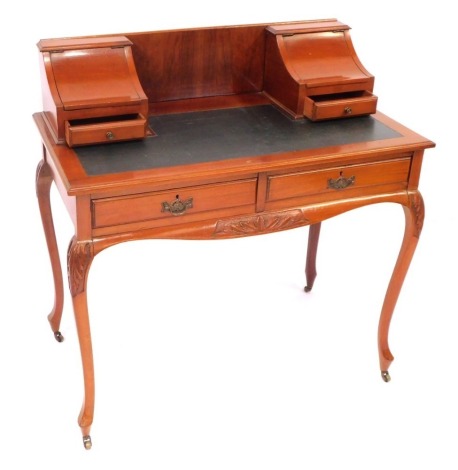 An early 20thC mahogany lady's Carlton House style writing desk, with two lift up stationery compartments, with drawers below, green leatherette inset top, over a pair of frieze drawers, over leaf carved slender cabriole legs, on castors, 94cm high, 91cm 