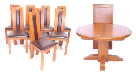 An oak circular draw leaf dining table, raised on a square central column, above X frame block feet, 77cm high, 123cm wide, 178cm extended, together with eight light oak single dining chairs, with brown leather seats and panel backs. (9)