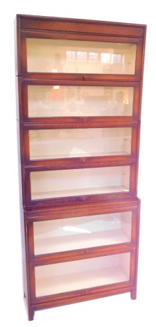 An early 20thC oak Globe Wernicke style bookcase, with six glazed up and over doors, raised on square feet, 208cm high, 67cm wide, 30.5cm deep.