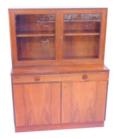 A Bodafors Swedish teak cupboard bookcase, the top with two glazed doors enclosing two shelves, above two drawers over cupboard doors, raised on a plinth base, 132cm high, 100cm wide, 45cm deep.