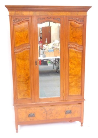 A Victorian mahogany and walnut double wardrobe, the outswept pediment with a dentil moulding, above a glazed central door, inset bevel glass, opening to reveal hanging hooks, over one long frieze drawer, raised on turned feet, 199.5cm high, 127cm wide, 1