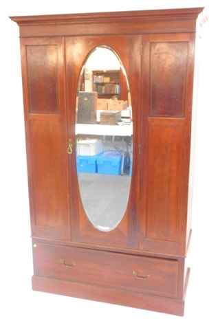 An Edwardian mahogany and line inlaid double wardrobe, the out swept pediment over a central door inset oval bevelled glass, opening to reveal hanging hooks, over a long frieze drawer, raised on a plinth base, 106cm high, 305cm wide, 53cm deep.