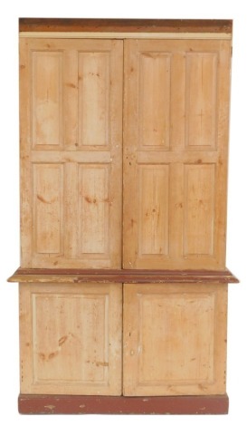 A Georgian pine and later painted housekeeper's cupboard, with two door upper section opening to reveal three shelves, above a pair of further doors opening to reveal three drawers over a recess, raised on a plinth base, 262cm high, 151cm wide, 63cm deep