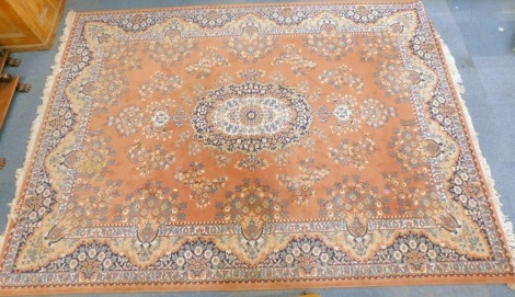 An Ardebil salmon ground rug, decorated with a central medallion and floral motifs, within repeating floral borders, 350cm x 250cm.