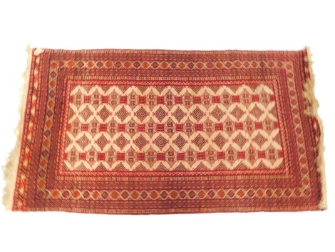 An Afghan cream ground rug, decorated with three rows of joined medallions and geometric motifs, within repeating geometric borders, 195cm x 110cm.