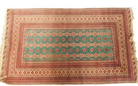 An Afghan turquoise and cream ground rug, decorated with three rows of joined medallions and geometric motifs, within repeating geometric borders, 220cm x 130cm.