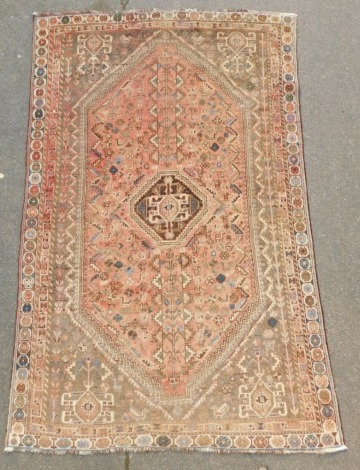 A Persian red ground rug, the central field decorated with a medallion, birds, and animals, within repeating floral and geometric borders, 260cm x 163cm.