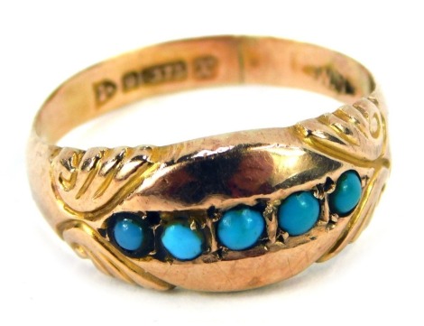 A 9ct gold turquoise dress ring, the panel design set with five turquoise, with scroll design shoulders, late Victorian/early Edwardian, ring size K½, 1.5g all in.