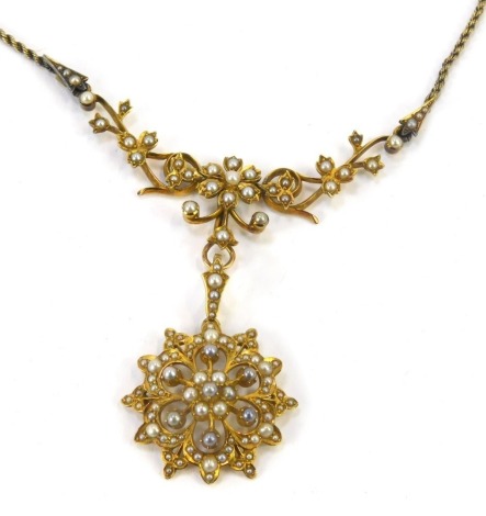 An Edwardian seed pearl necklace, the flower drop design 3.5cm high, with articulated flower and vine support 7.5cm wide, on a rope twist necklace, the necklace yellow metal stamped 15ct, the chain unmarked, 32cm long, 19.2g all in.