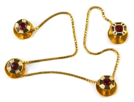 A set of gentleman's collar studs, joined by box link chain, each stud with red, white, and black enamel, yellow metal, one stud marked 22ct, the chain unmarked, 29cm long overall, 13.6g all in.