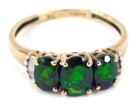 A 9ct gold diopside and diamond 9ct gold dress ring, with arrangement of three diopside stones, totalling approximately 1.06ct, with tiny diamond set shoulders, with a Christine Swann certificate of authenticity, ring size N½, 1.7g all in.