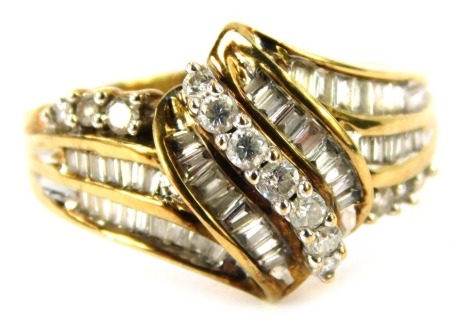 A 9ct gold and diamond dress ring, set with central buckle design set with baguette and round brilliant cut diamonds, ring size N, 3.7g all in.