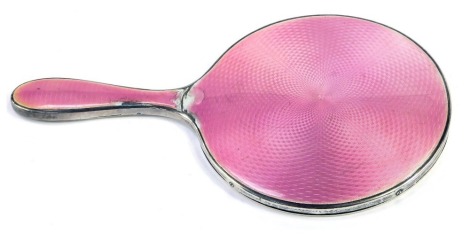 A George V silver and enamel hand held mirror, with pink guilloche enamel, Birmingham hallmarks rubbed, 27cm high. (AF)