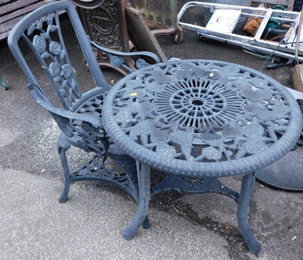 A black plastic patio table, and one chair.