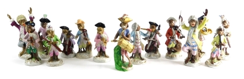 A comprehensive continental harlequin porcelain monkey band, to include conductor, in yellow jacket with arms raised, 21cm high, French horn player, violinist, further conductor and other various pieces, pottery monkey band drummer, various others, some w