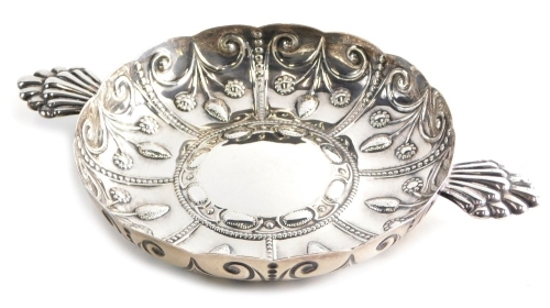 An Edward VII silver dish, by Wakeley and Wheeler, repousse decorated with panels of flowers, with a raised centre and elaborate handles, London 1903, 35cm wide, 20.4oz.