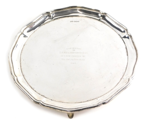 A George V silver salver, by Atkin Brothers, with piecrust edge on triple feet, marked Presented to EH Hollingworth esq by a Few Friends of the Herne Bay Club 1914, Sheffield 1913, 27cm wide, 16.5oz.