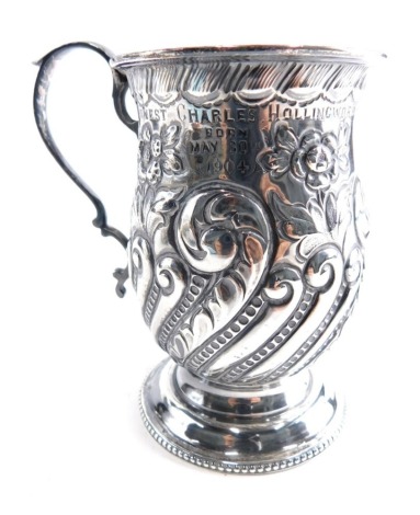 An Edwardian silver mug, by B Worth and Sons, with bell shaped body, ear shaped handle, repousse decorated with scrolls and flowers on circular foot, Sheffield 1905, 10cm high, 3.6oz.