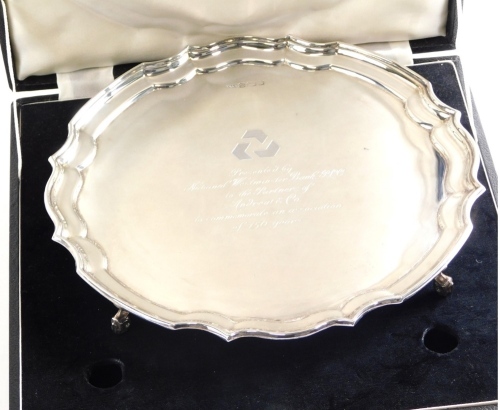 An Elizabeth II silver salver, by Butts and Dore Ltd, with piecrust edge on quadruple scroll feet, engraved Presented By National Westminster Bank Plc To The Partners Of Andrew & Co To Commemorate An Association of 150 Years, Sheffield 1980, 25cm wide, 15