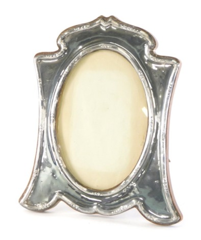 An Edward VII silver photograph frame, with oak easel back and plain oval centre, Birmingham 1910, 28cm high, the inner section 19cm x 13cm.