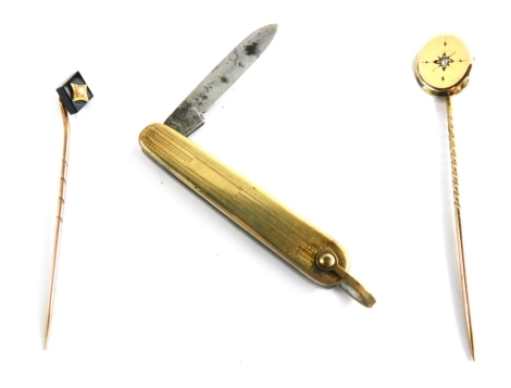 A 9ct gold diamond set stick pin, of oval design with central diamond, a 9ct gold stick pin with jet and seed pearl and a yellow metal coloured cased pen knife, 3.6g all in. (3)