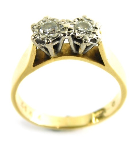 A diamond two stone dress ring, set with two round brilliant cut diamonds, each in an illusion setting, approximately 0.15 carats, in a raised basket with rubbed shoulders, ring size Q½, 5.5g all in.