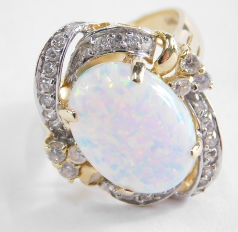 An opal and diamond dress ring, of twist design with central oval opal, in claw setting surrounded by sprays of diamonds, on a raised basket, on a yellow metal band stamped 585, ring size N½ ,6g all in.