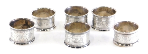 Six various silver napkin rings, each chased with leaves and scrolls, Birmingham 1925, 1921, etc., 5cm diameter, 3oz. (6)