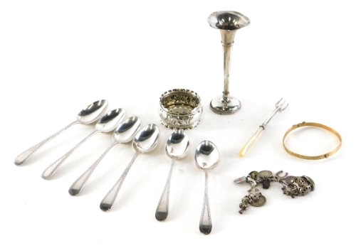 Various silver and related effects, a sterling and other charm bracelet with a number of charms, silver and base metal, etc., Lincoln Imp, 2cm high, etc., a quantity of various silver teaspoons, unmarked yellow coloured bangle, Old English teaspoons, napk