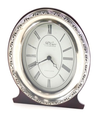 An Elizabeth II silver fronted mantel clock, marked R Carr Clock Makers, with 8cm wide paper dial printed with Roman numerals, with a raised outer floral band, marked England, Sheffield 1989, 17cm high.