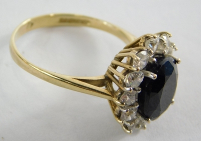 A 9ct gold cluster ring, set with central dark blue paste stone, surrounded by cz, in a raised basket setting, ring size M½, 3.9g all in. - 2