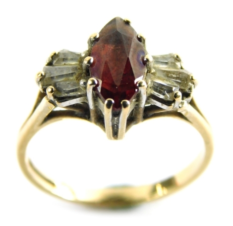 A 9ct gold garnet and cz set dress ring, in the Art Deco style with marquise shaped central garnet flanked by six baguette cut cz stones, on V splayed shoulders, ring size N½ 2.7g all in.