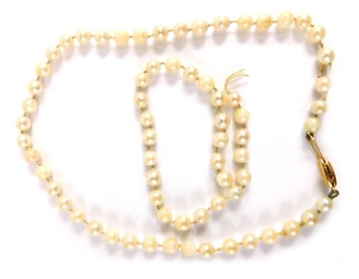 A cultured pearl single strand necklace, on a knotted string strand, with cream lustre pearls, and a yellow metal clasp stamped 375, approx 53cm long and a smaller strand. (AF)