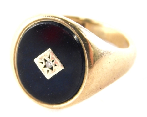 A 9ct gold signet ring, with oval signet, set with jet and a central tiny diamond, on a plain band, ring size P½, 7.2g all in.